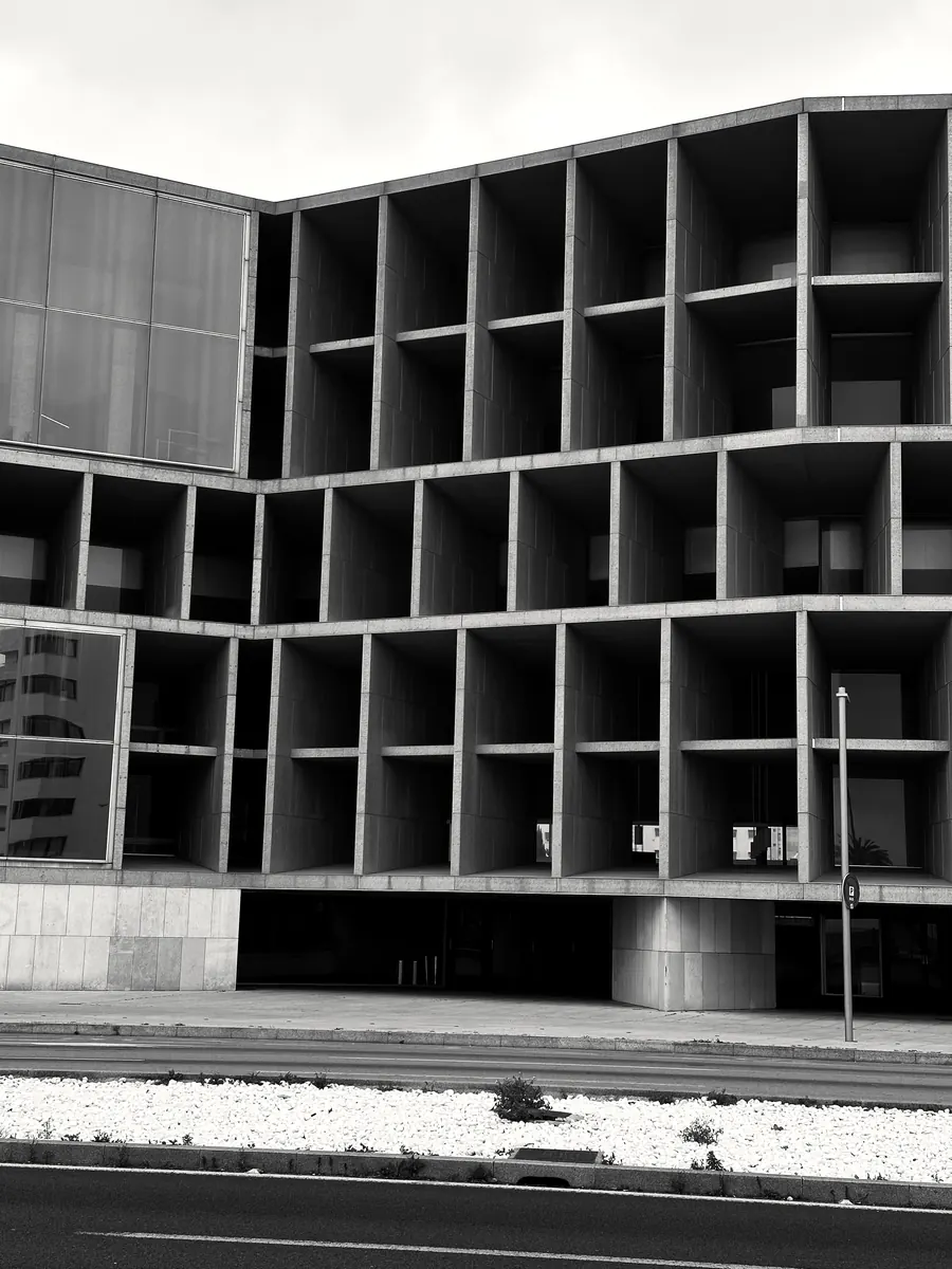 Edificio de hormigón con fachada de retícula profunda.